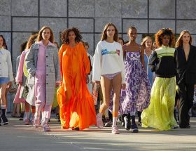 Foto de um desfile mostrando as tendências de moda com vários modelos com roupas bem coloridas.