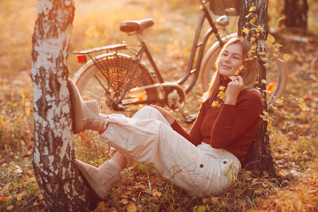 Foto de uma mulher entre a natureza no outono, vestida com estilos urbano.