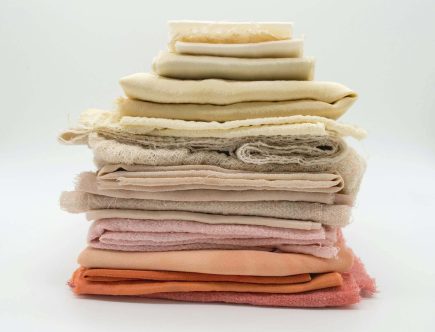 Foto de uma pilha de tecidos em cores claras.