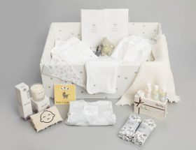 Foto de uma caixa com roupas de bebê, representando a bolsa para maternidade.