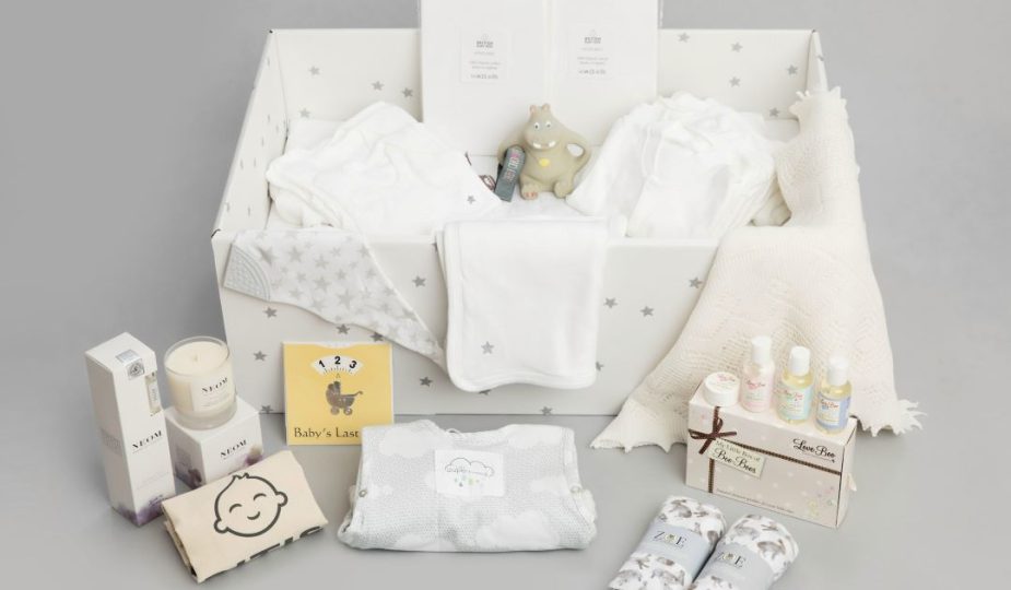 Foto de uma caixa com roupas de bebê, representando a bolsa para maternidade.