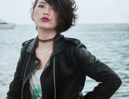 Foto de uma mulher usando uma jaqueta preta de material sintético.