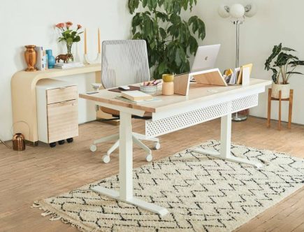 Foto de escritório em home office, com mesa, cadeira e tapete.