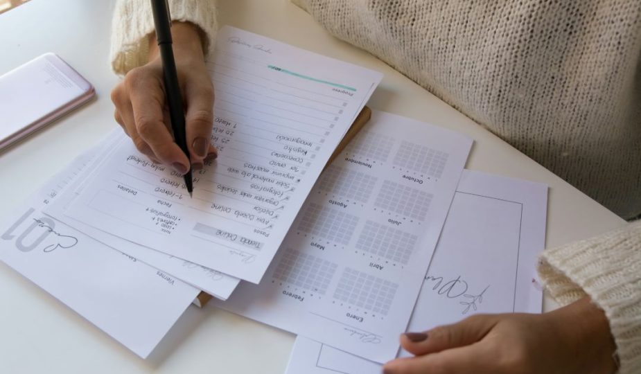 Foto de uma mulher fazendo suas anotações em um planner.