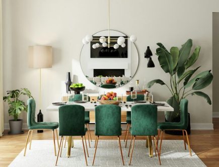 Foto de uma sala de jantar com mesa de madeira e cadeiras na cor verde.